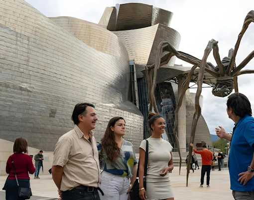 Tourist group with guide in front of Guggenheim Museum Bilbao and "Maman" sculpture by Louise Bourgeois.