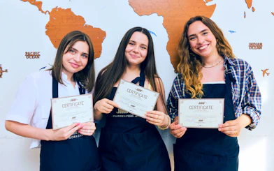 Participants holding certificates at Traditional Chimney Cake Workshop, Budapest.