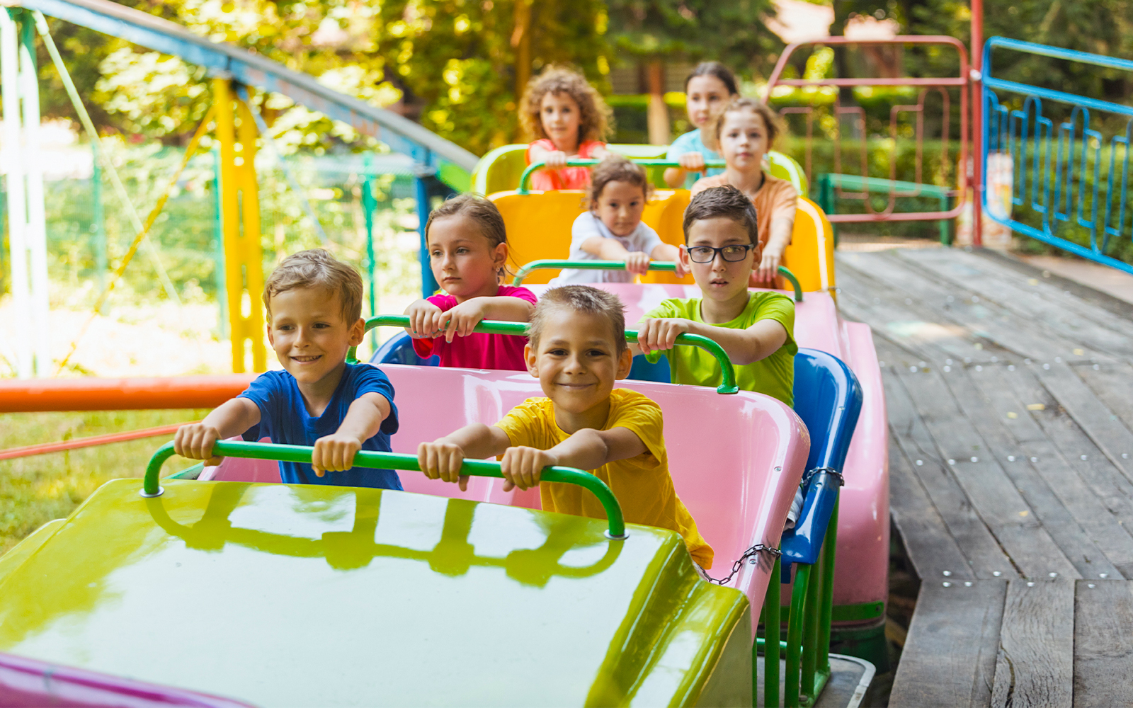 Kids enjoying a colorful roller coaster ride at an amusement park.