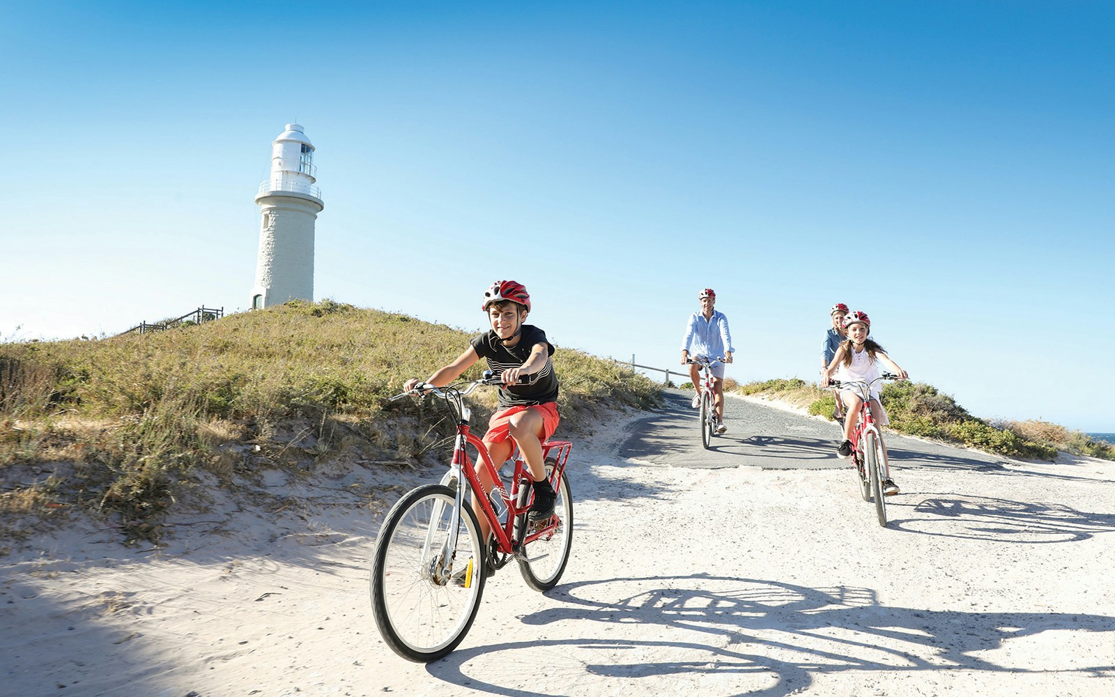 Group cycling towards Wadjemup Lighthouse on Rottnest Island, Western Australia.