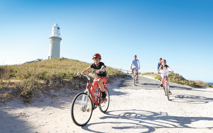Group cycling towards Wadjemup Lighthouse on Rottnest Island, Western Australia.