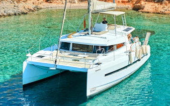 Catamaran sailing near Dia Island in clear turquoise waters.