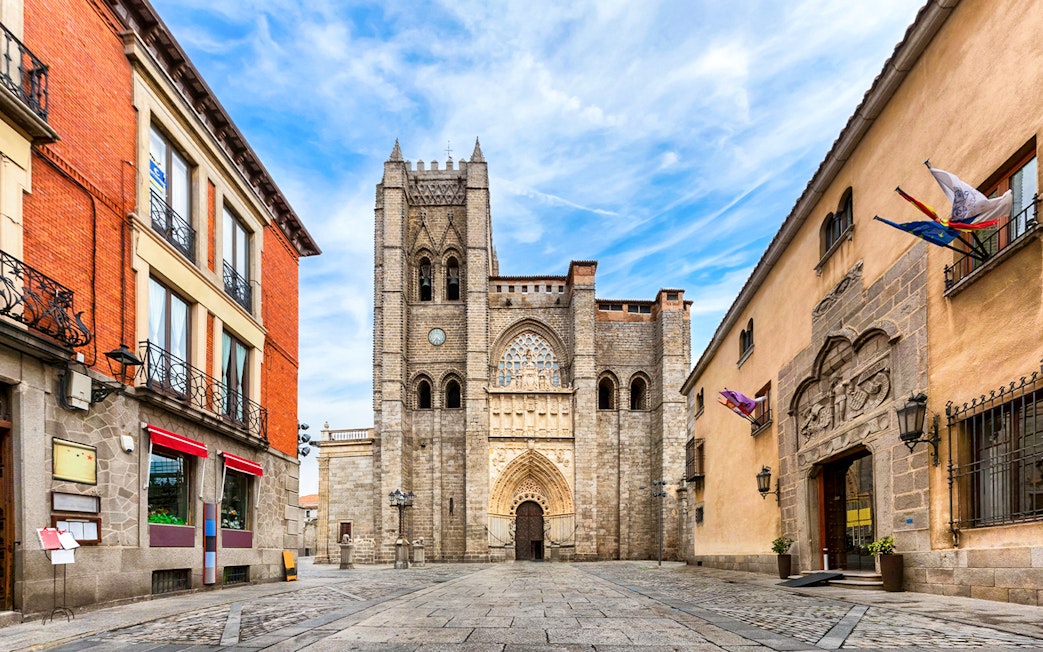 Ávila Cathedral facade with surrounding historic buildings in Spain.