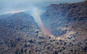 Aerial view of Mount Etna's volcanic crater with visible lava flow.