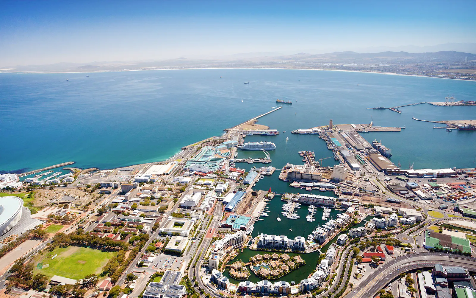 Aerial view of Cape Town cityscape with harbor and coastline.