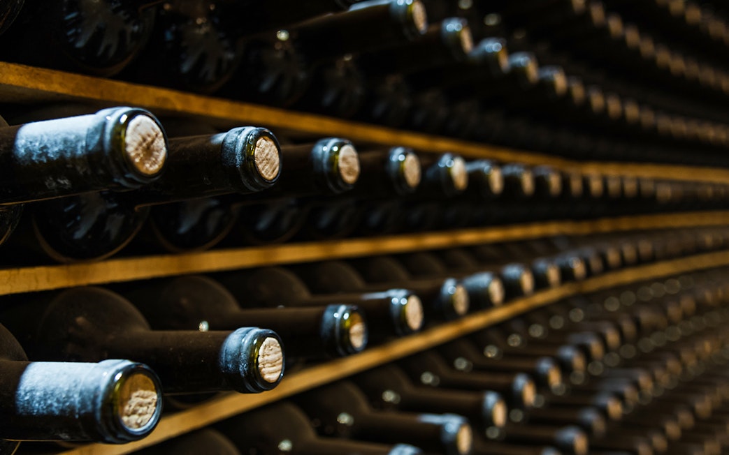 Wine bottles aging in a cellar during Vouvray wine tour.