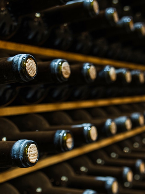 Wine bottles aging in a cellar during Vouvray wine tour.