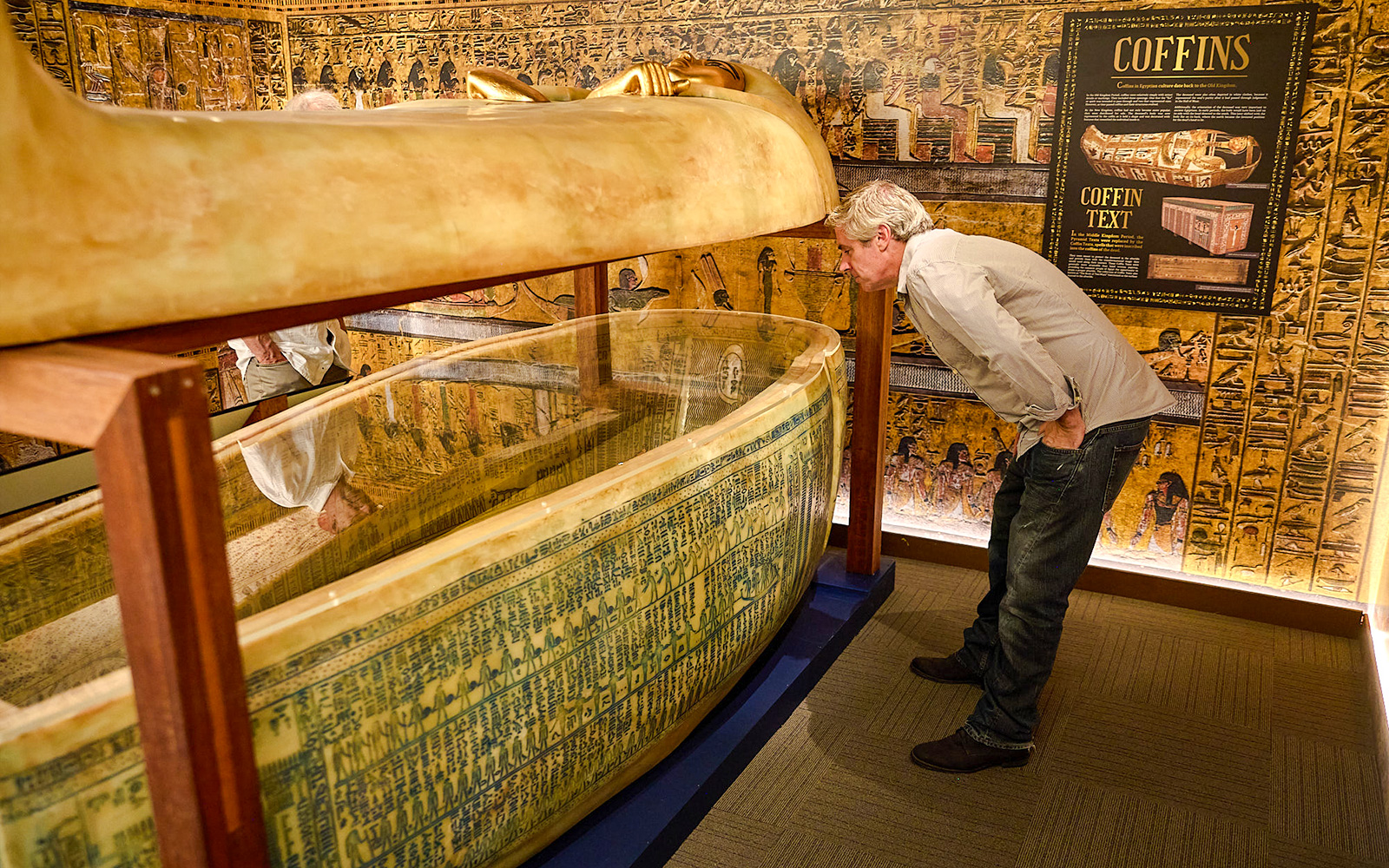 Visitor examines Egyptian sarcophagus at Tomb of the Pharaoh exhibit, Cairns.