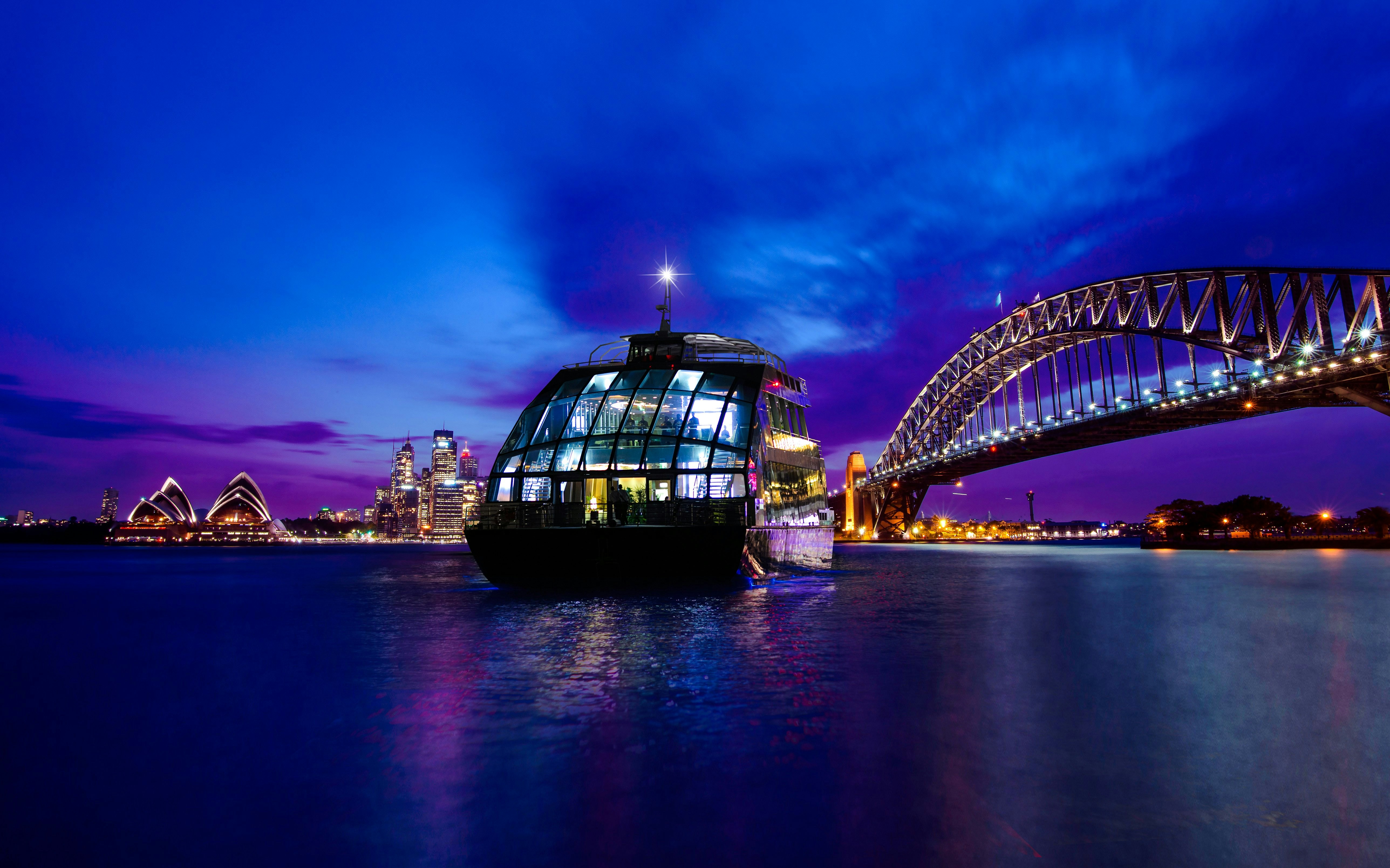 Cruise ship on Sydney Harbour with views of the Opera House and Harbour Bridge at night.