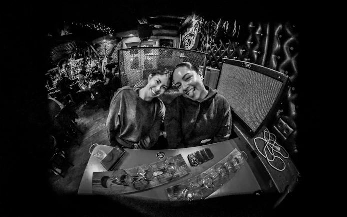 Two people smiling at a bar in Reykjavík during a private bar crawl with drinks.