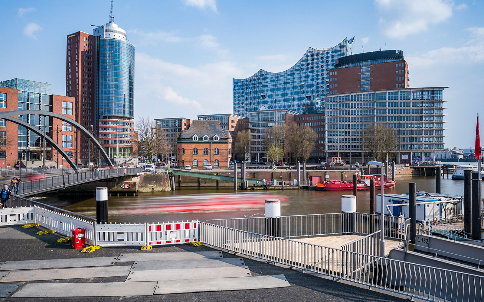 Elbphilharmonie and Hamburg harbor with boats and modern buildings in view.