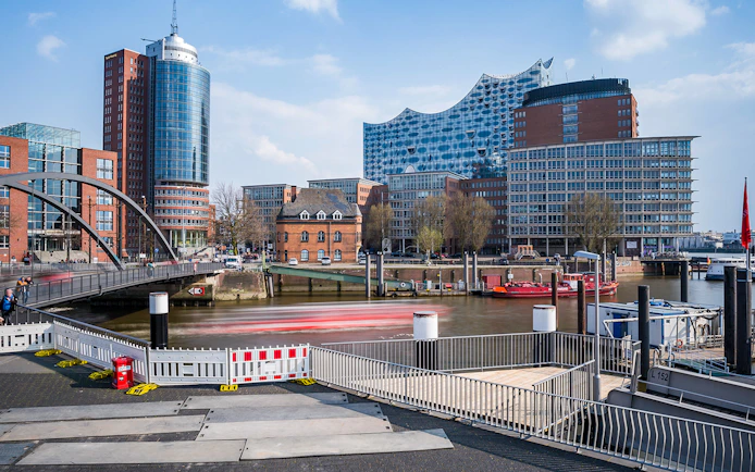 Elbphilharmonie and Hamburg harbor with boats and modern buildings in view.