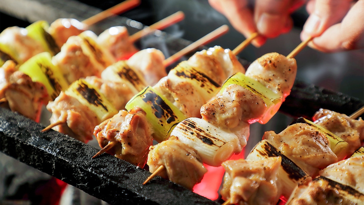 Grilled yakitori skewers cooking over charcoal at TeamLab Planets.
