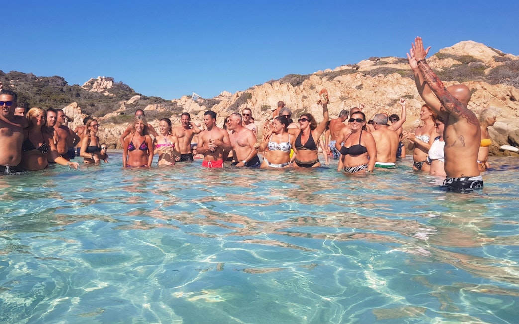 Group enjoying the water during a catamaran tour in La Maddalena, Italy.