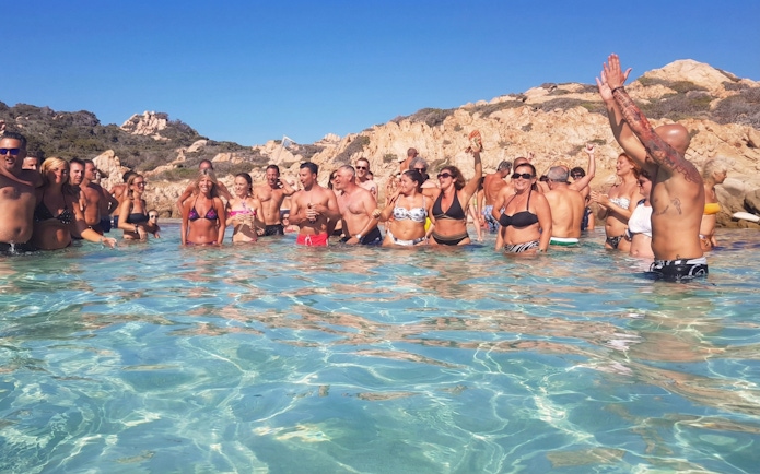Group enjoying the water during a catamaran tour in La Maddalena, Italy.