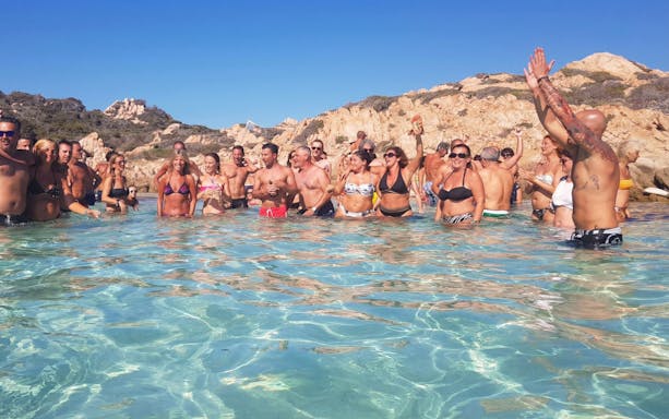 Group enjoying the water during a catamaran tour in La Maddalena, Italy.
