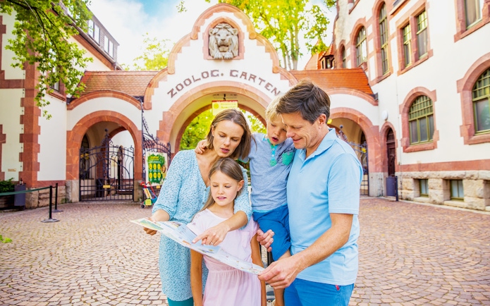 Family exploring map at Zoo Leipzig entrance.