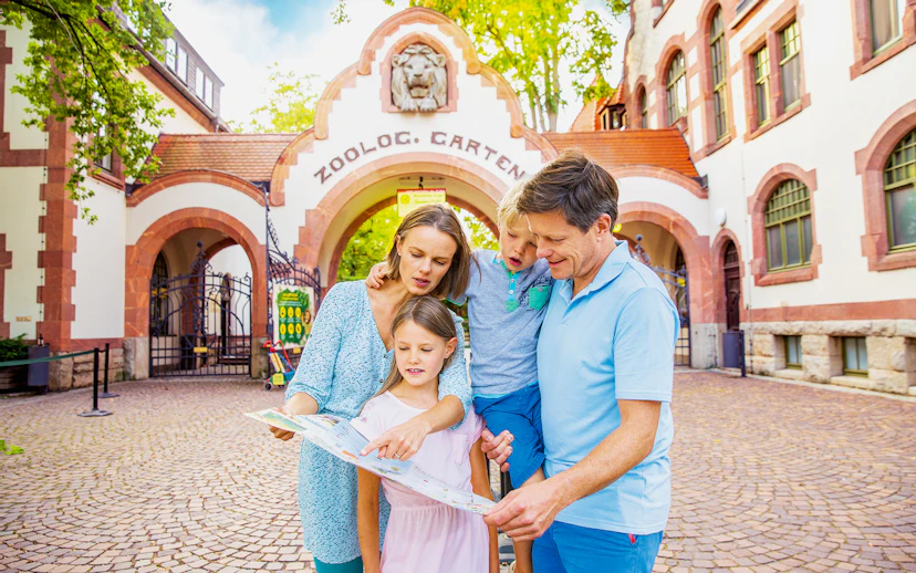 Family exploring map at Zoo Leipzig entrance.