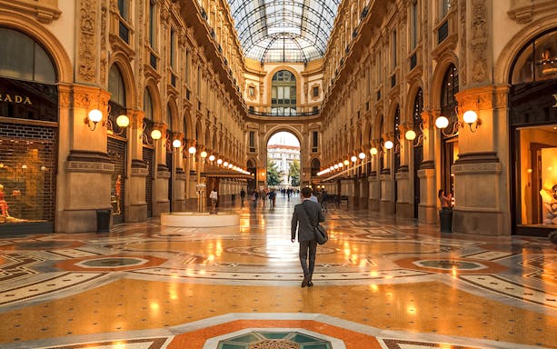 Galleria Vittorio Emanuele II interior with people walking, Milan, Italy.