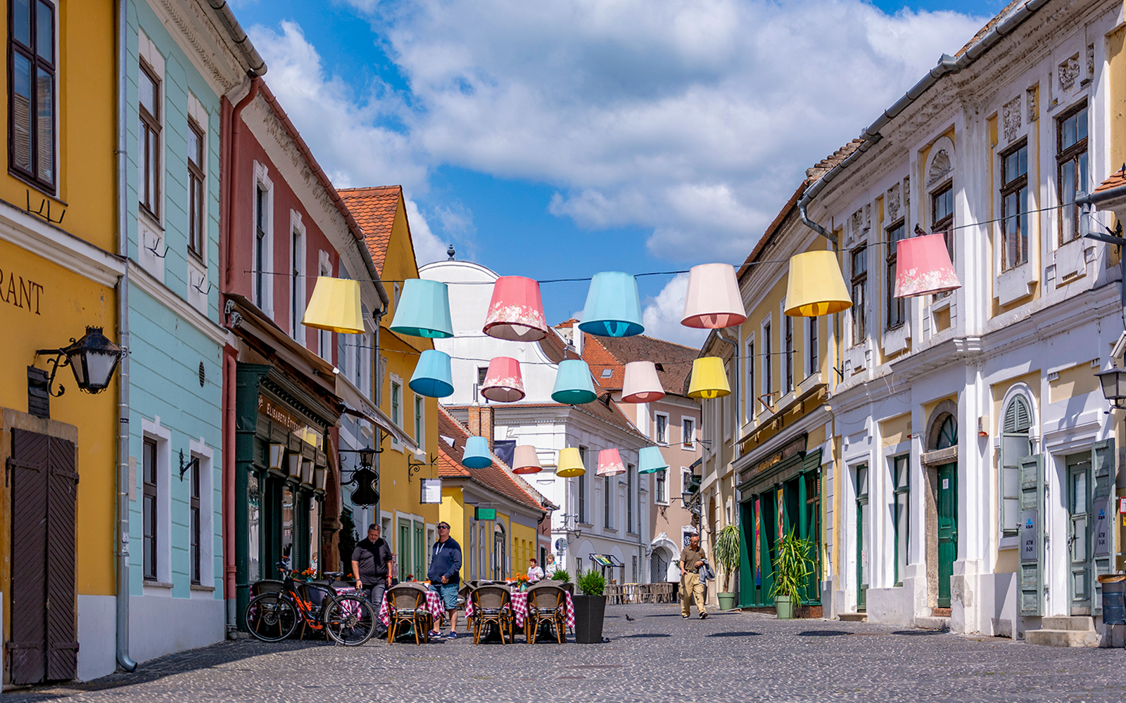 Colorful lampions hanging over a cobblestone street in the old town of Szentendre, Hungary.