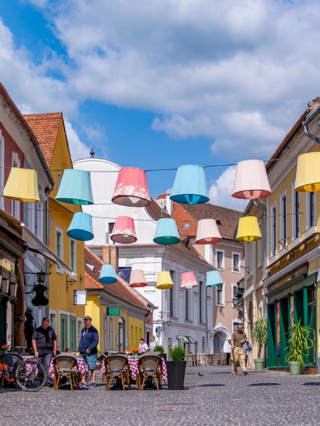 Colorful lampions hanging over a cobblestone street in the old town of Szentendre, Hungary.