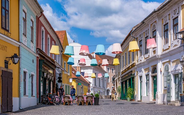 Colorful lampions hanging over a cobblestone street in the old town of Szentendre, Hungary.