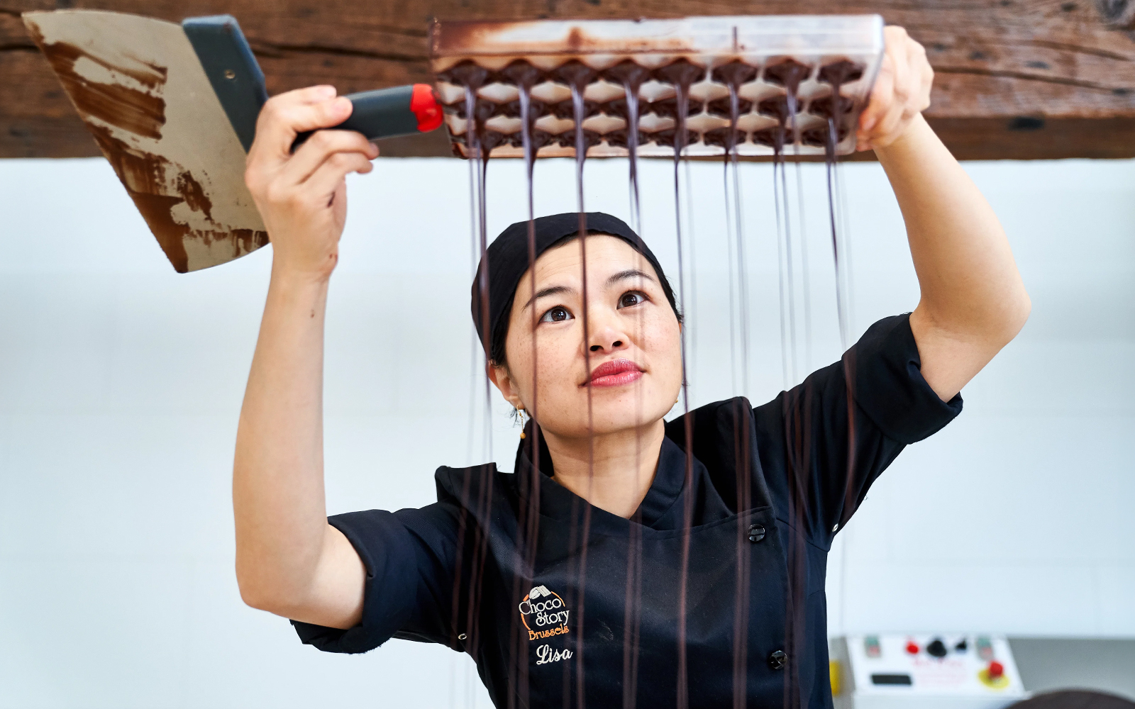 Chocolatier pouring chocolate into molds at Choco Story Brussels.