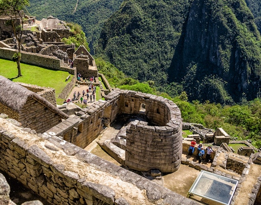 Machu Picchu Sun Temple with stone walls and panoramic mountain views.
