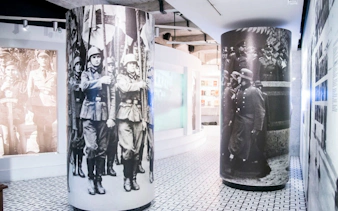 Krakow museum interior with historical military photos on cylindrical displays.