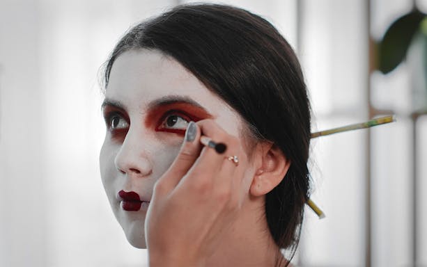 Applying makeup for Maiko makeover experience in Kyoto.