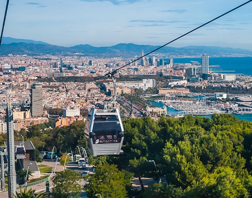 Montjuic Cable Car overlooking Barcelona cityscape and harbor.