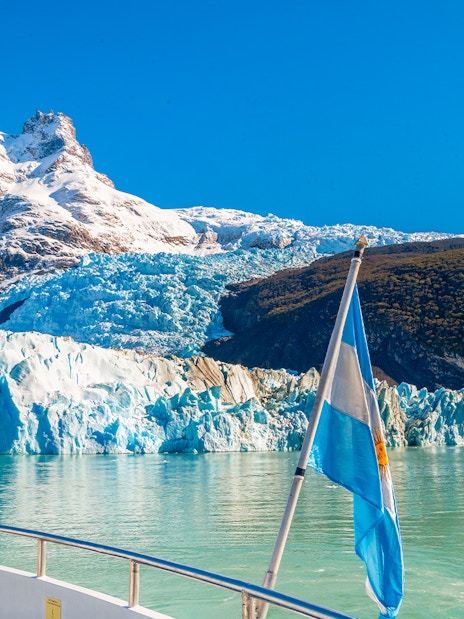 Boat approaching Spegazzini Glacier with snow-capped mountains in Los Glaciares National Park, Argentina.