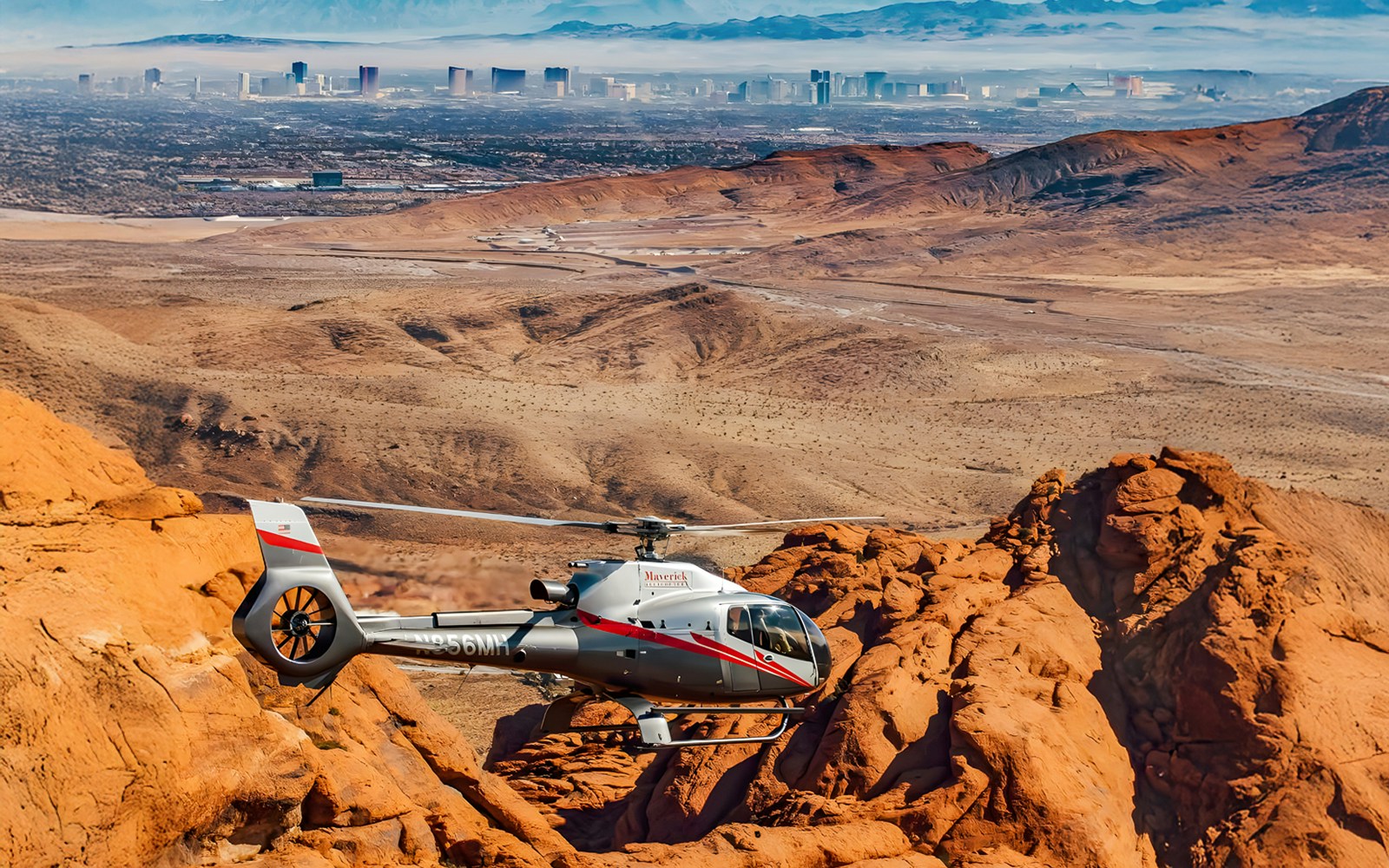 Maverick helicopter flying near Red Rock Canyon formations, Las Vegas.