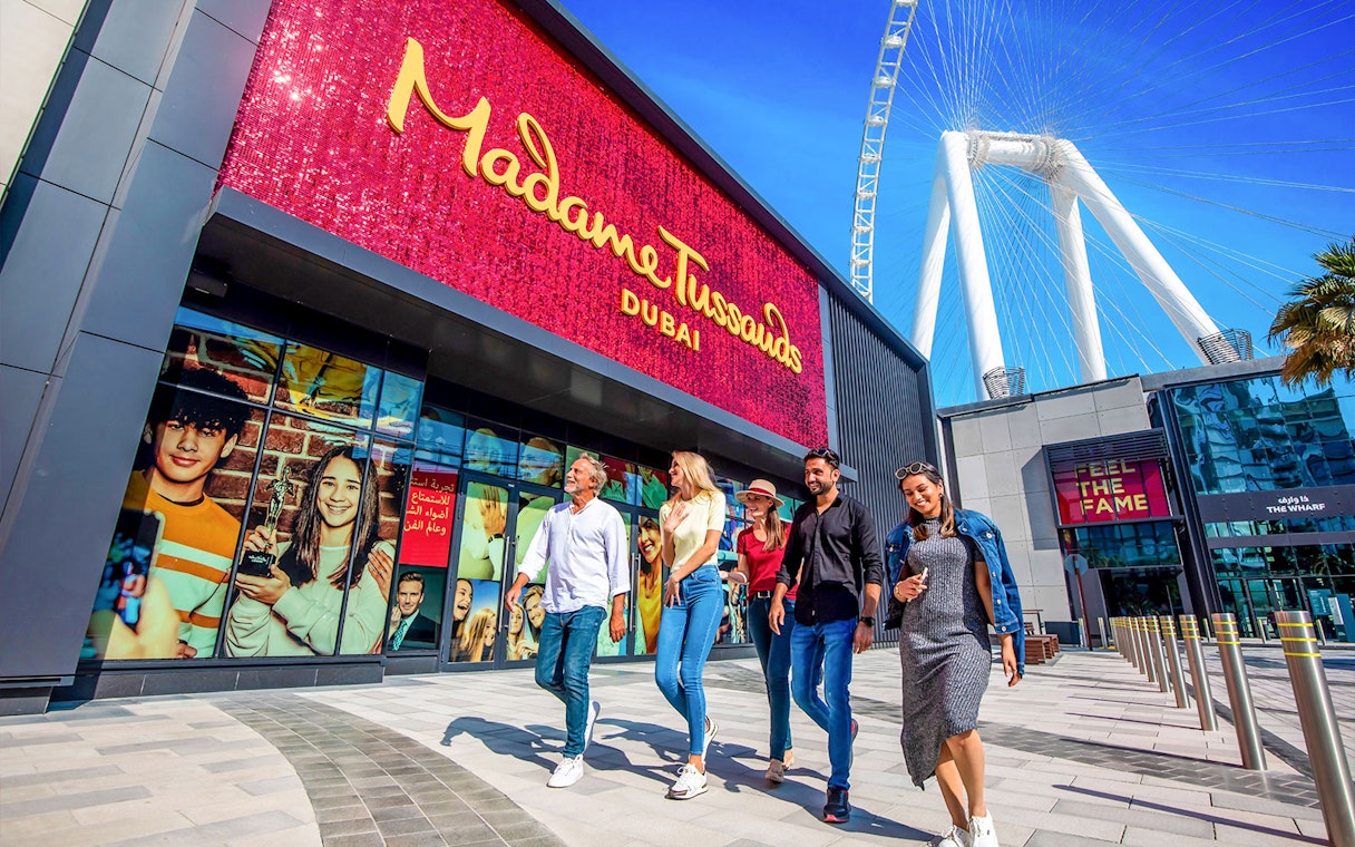 Visitors walking outside Madame Tussauds Dubai with Ain Dubai in the background.