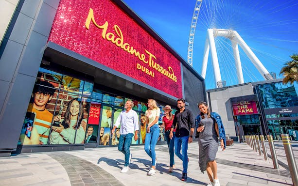 Visitors walking outside Madame Tussauds Dubai with Ain Dubai in the background.