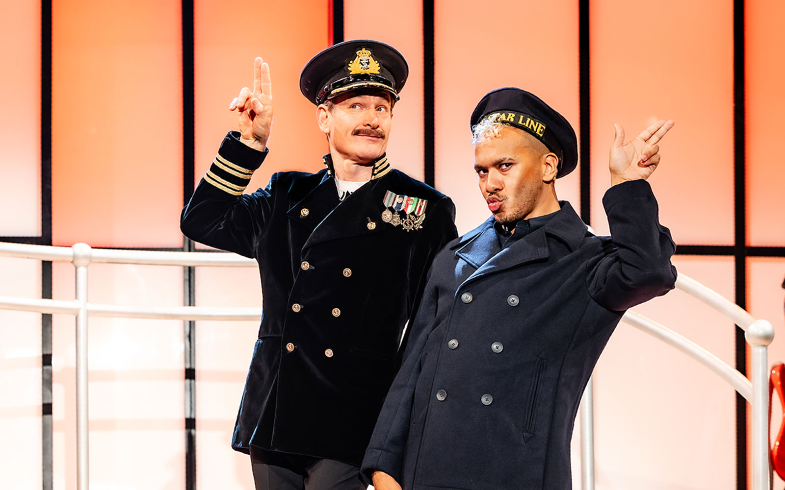Performers in naval costumes on stage during Titanique West End show.
