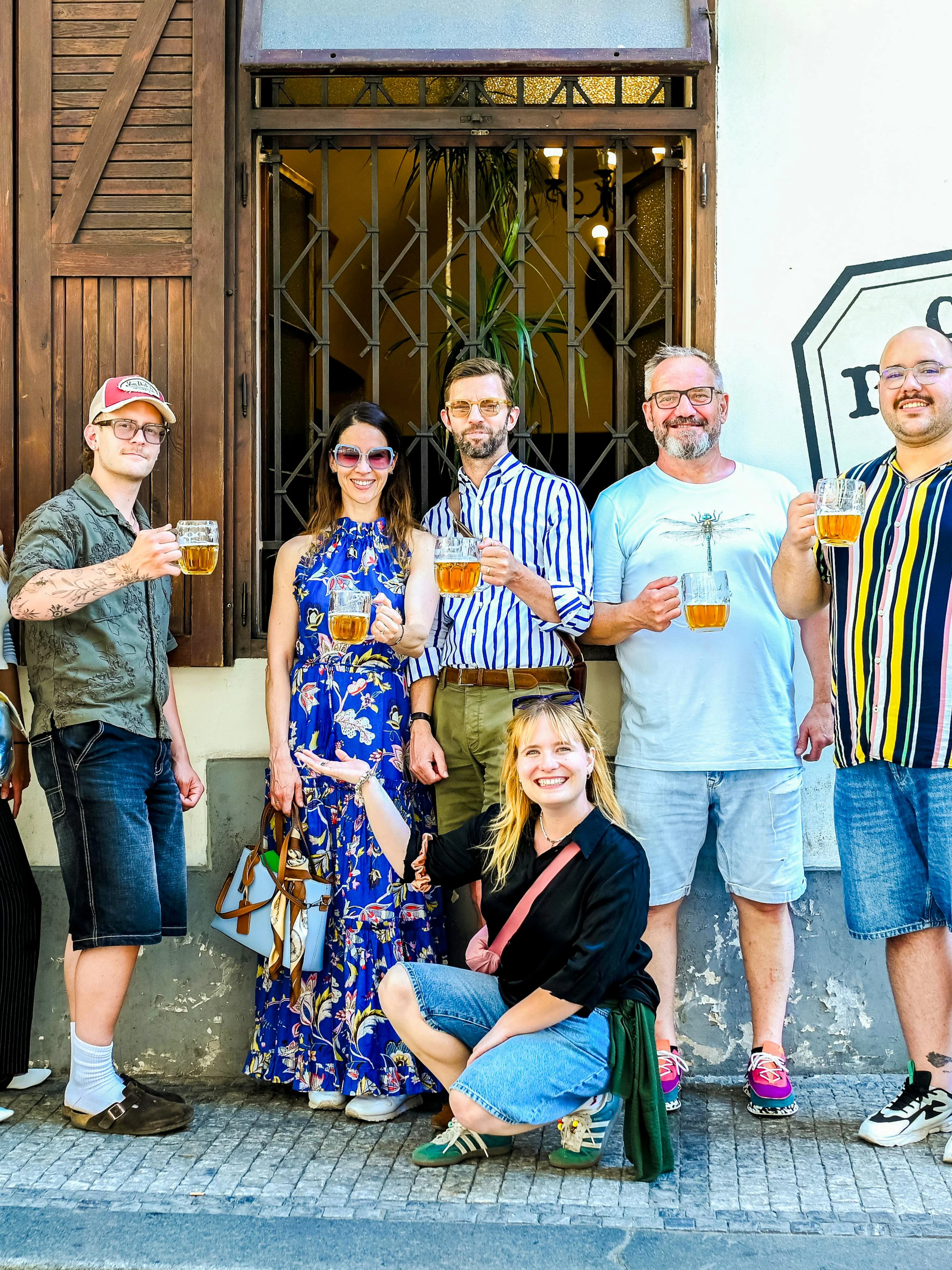 Group enjoying Czech beer on Prague food tour outside a local pub.