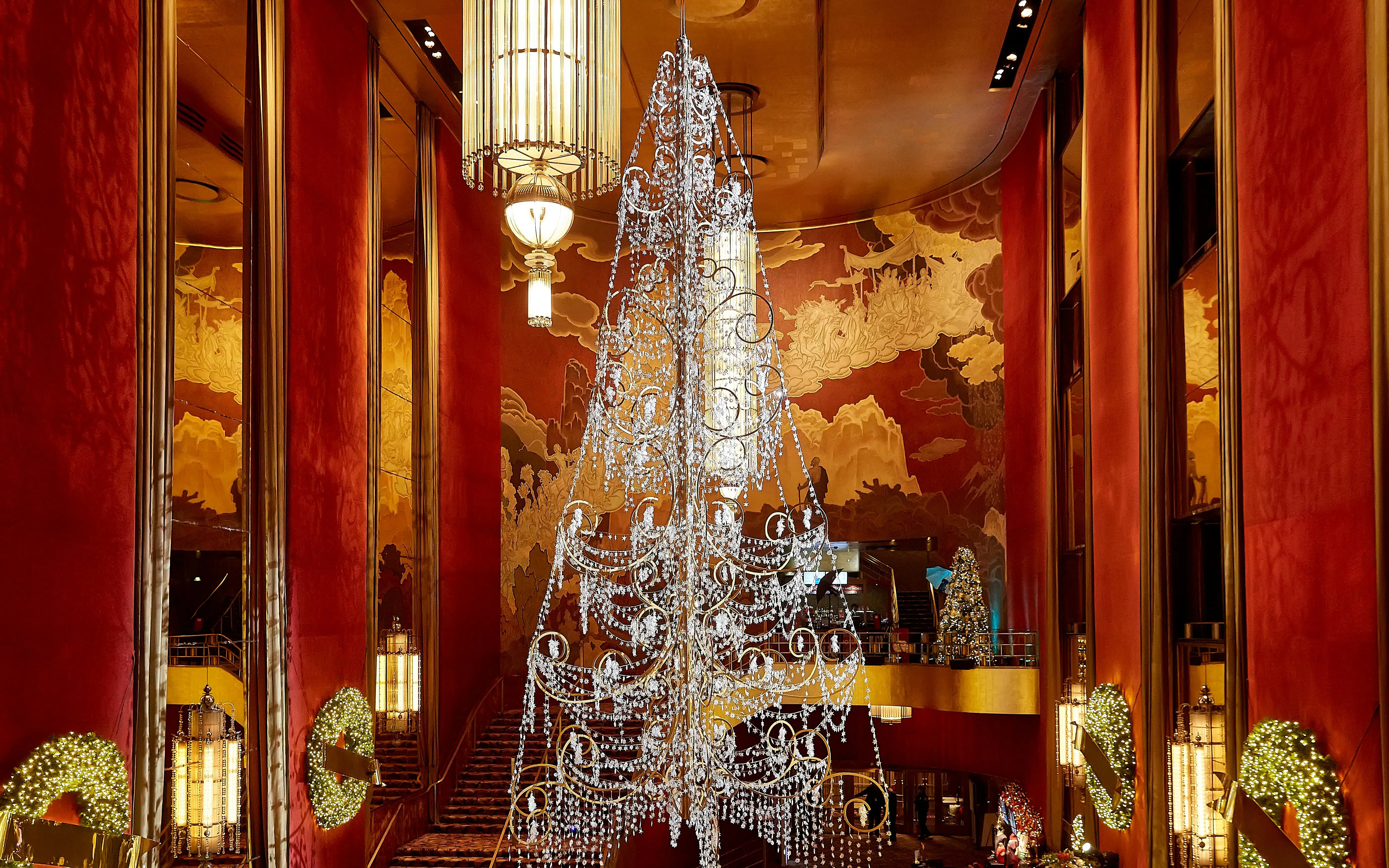 Radio City Music Hall lobby with chandelier and holiday decorations.