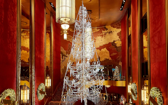 Radio City Music Hall lobby with chandelier and holiday decorations.