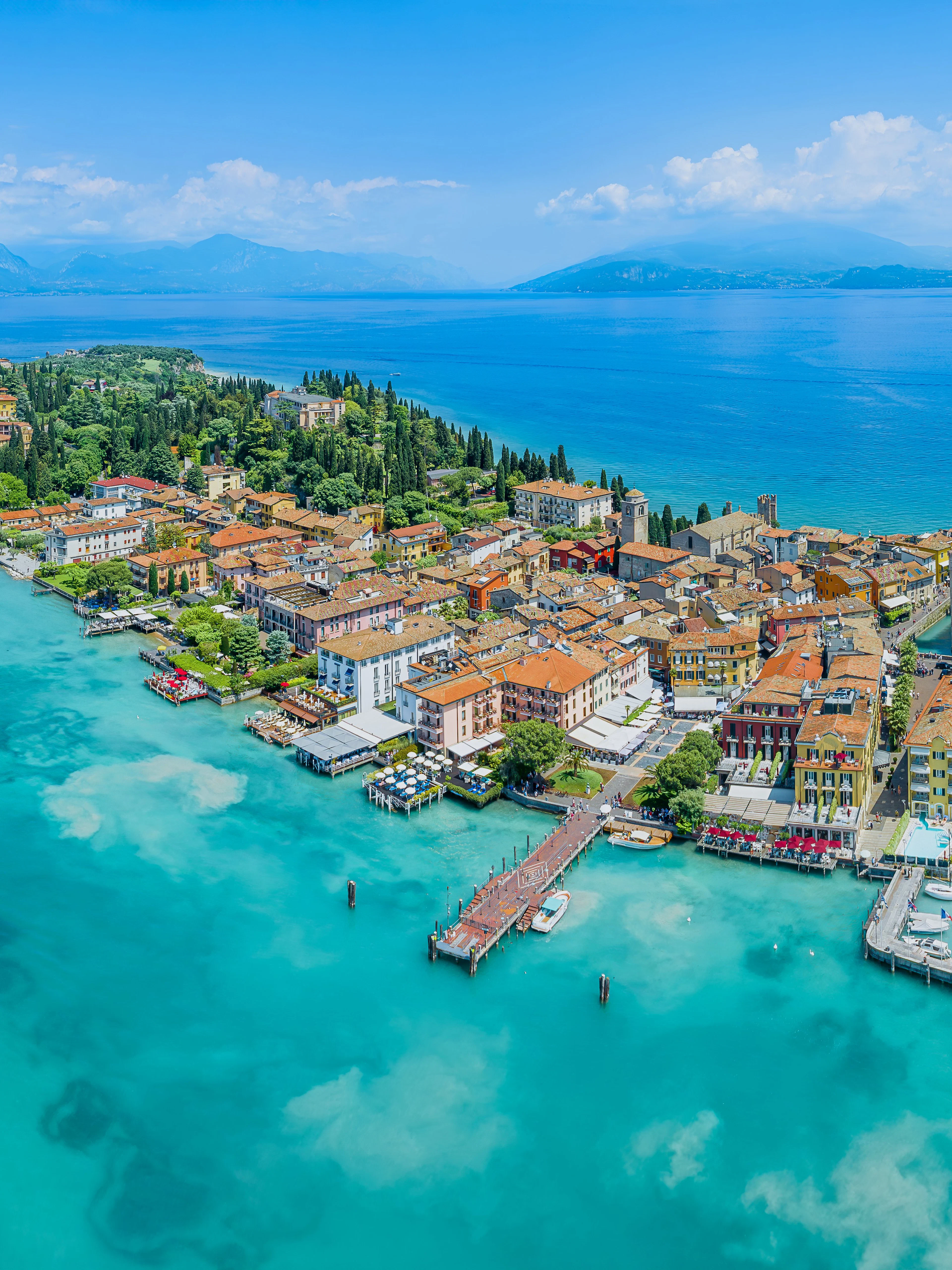 Aerial view of Sirmione town on Garda Lake, Italy, with Scaliger Castle and turquoise waters.