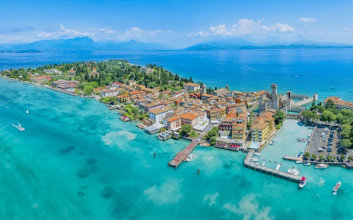 Aerial view of Sirmione town on Garda Lake, Italy, with Scaliger Castle and turquoise waters.
