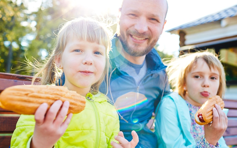 Family enjoying snacks on a sunny day outdoors.