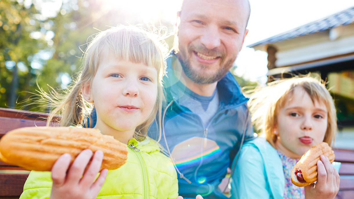 Family enjoying snacks on a sunny day outdoors.