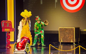 Piff the Magic Dragon stage performance in Vegas with colorful costumes and props.