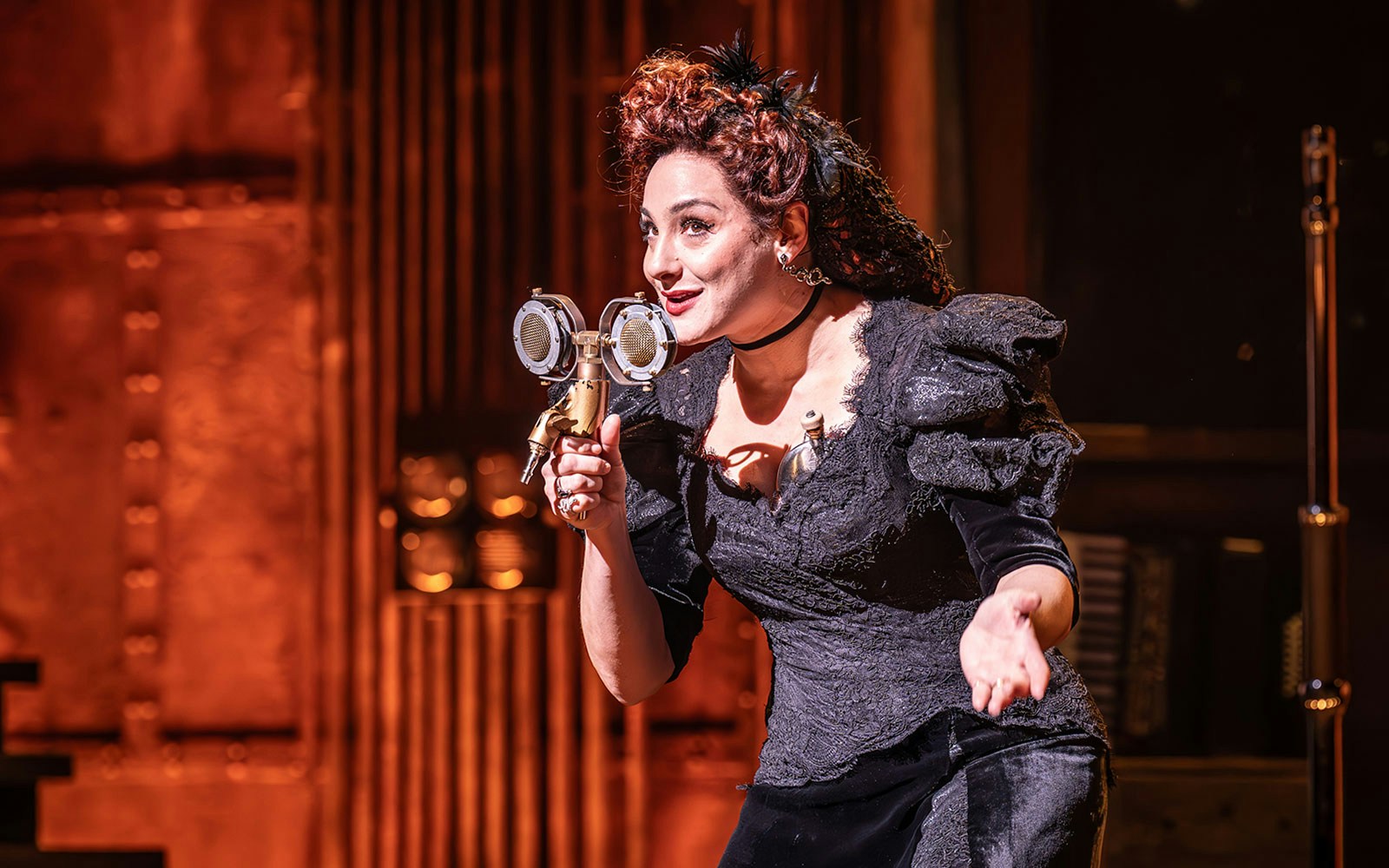 Performer in vintage attire telling ghost stories on stage.