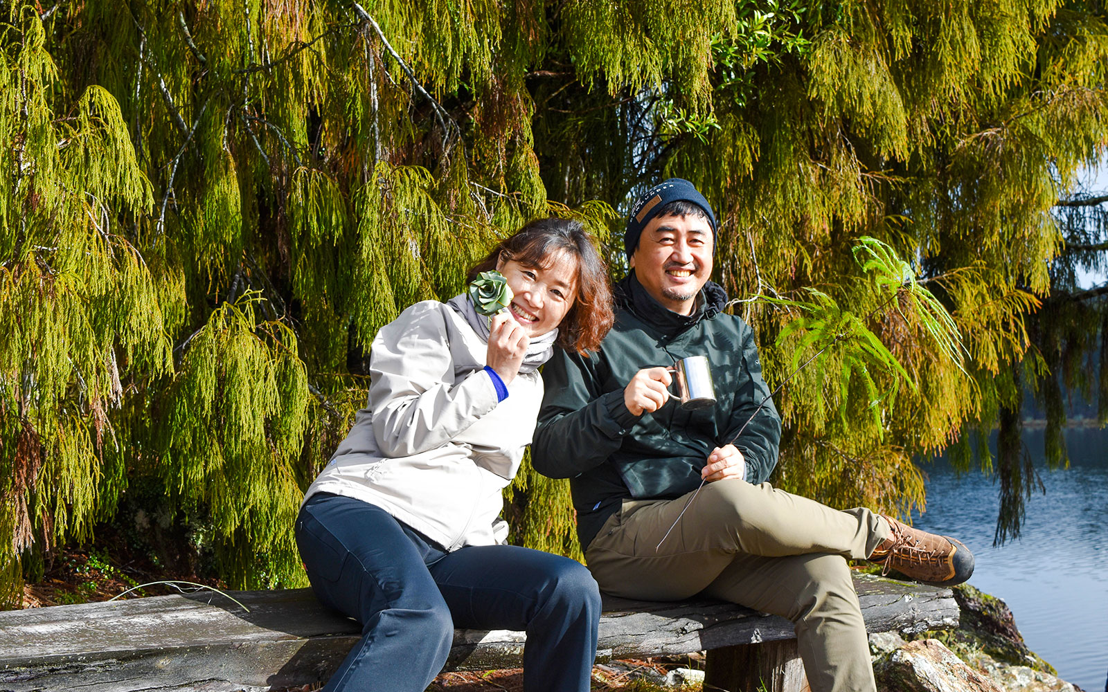 Tourists enjoying a break during a rainforest walk at Franz Josef, surrounded by lush greenery.