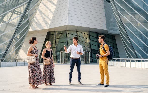 Guide leading a tour outside Foundation Louis Vuitton, Paris, France.