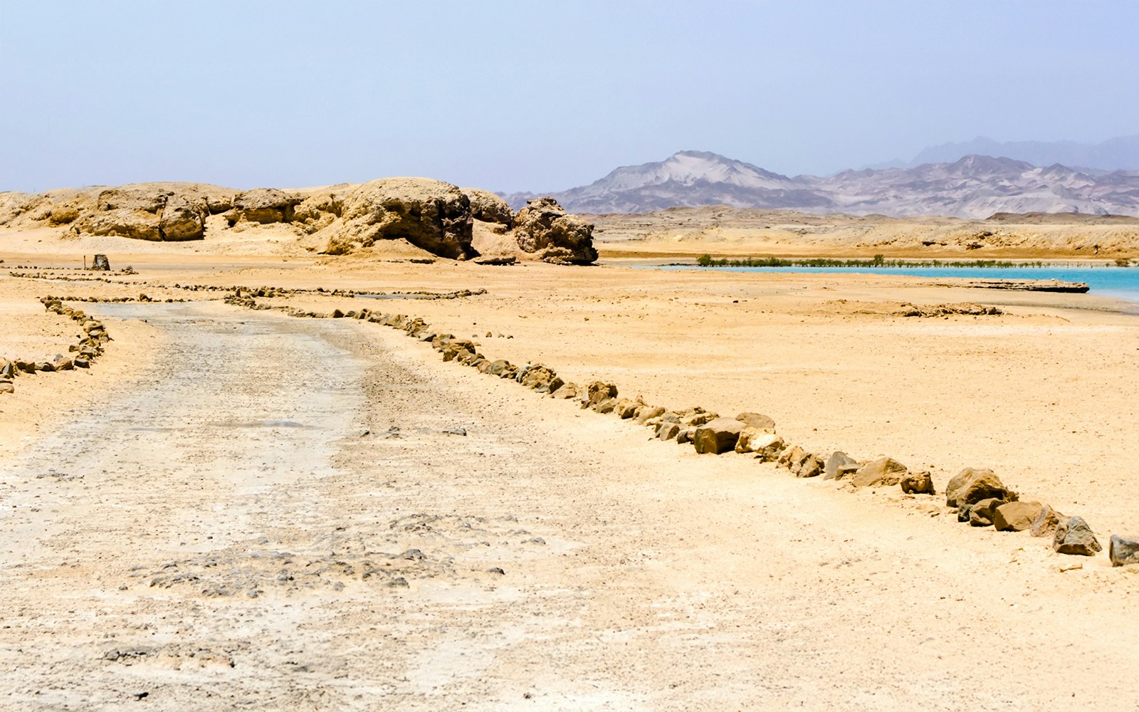Desert landscape with rocky path and distant mountains in Ras Mohamed National Park, Sinai, Egypt.