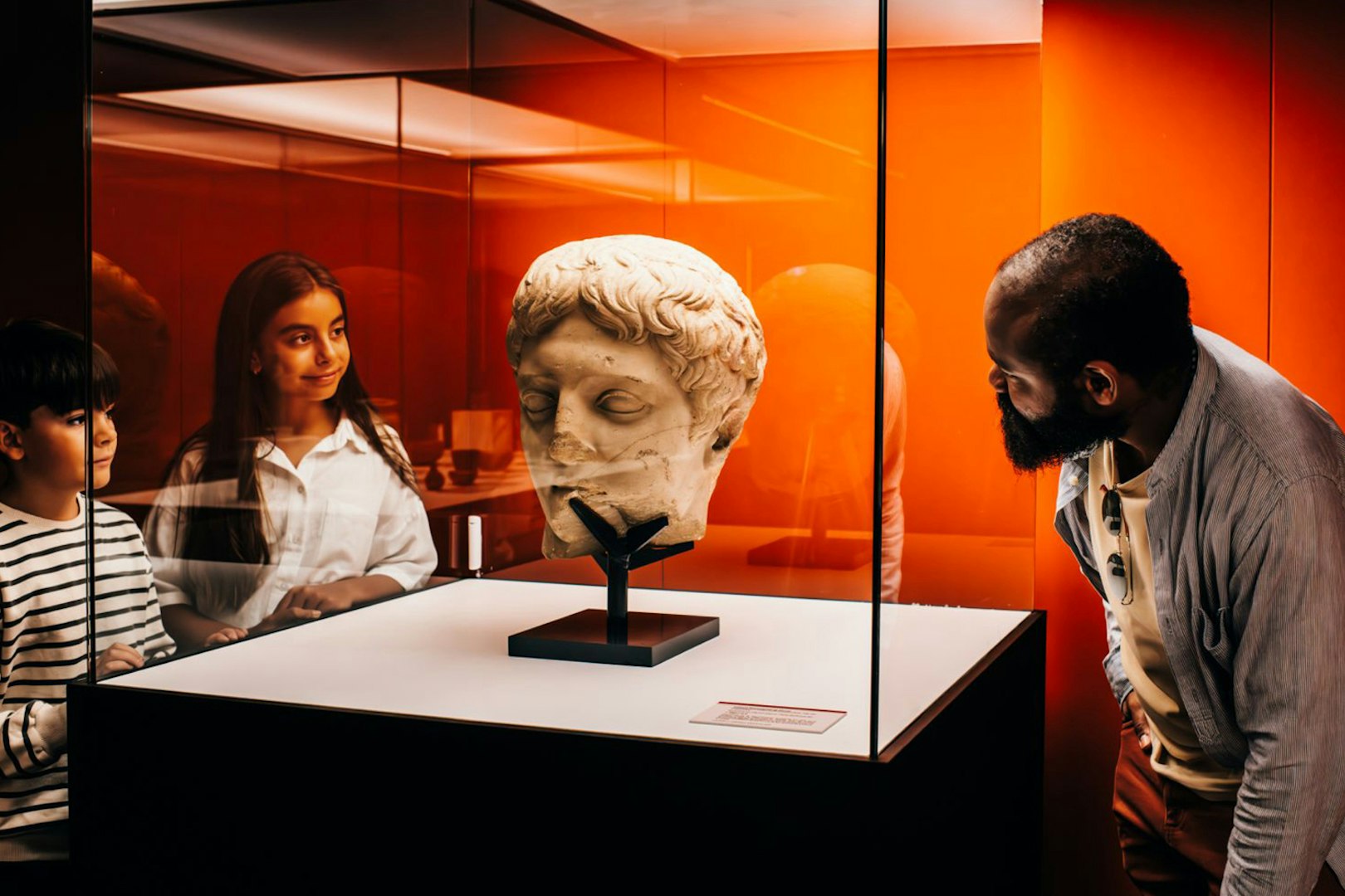 Visitors observing a Roman bust in a museum exhibit on Pompeii.