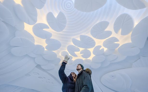 Guests admiring ice sculptures inside Arctic SnowHotel.